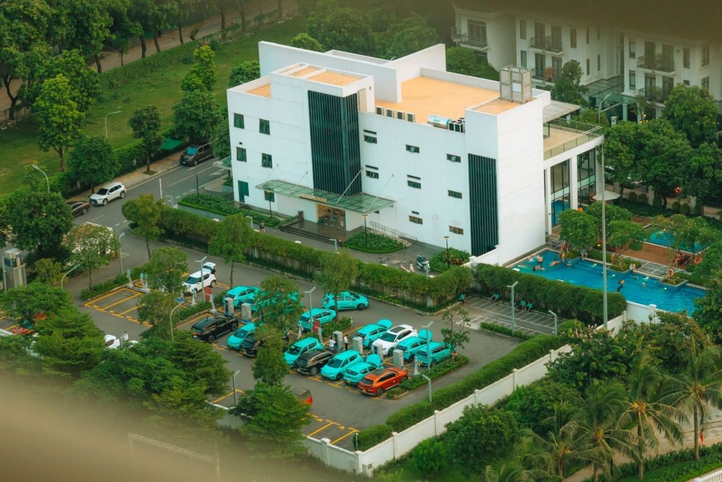 Aerial view of a Dubai residential community clubhouse, swimming pool, and parking area funded by owner service charges