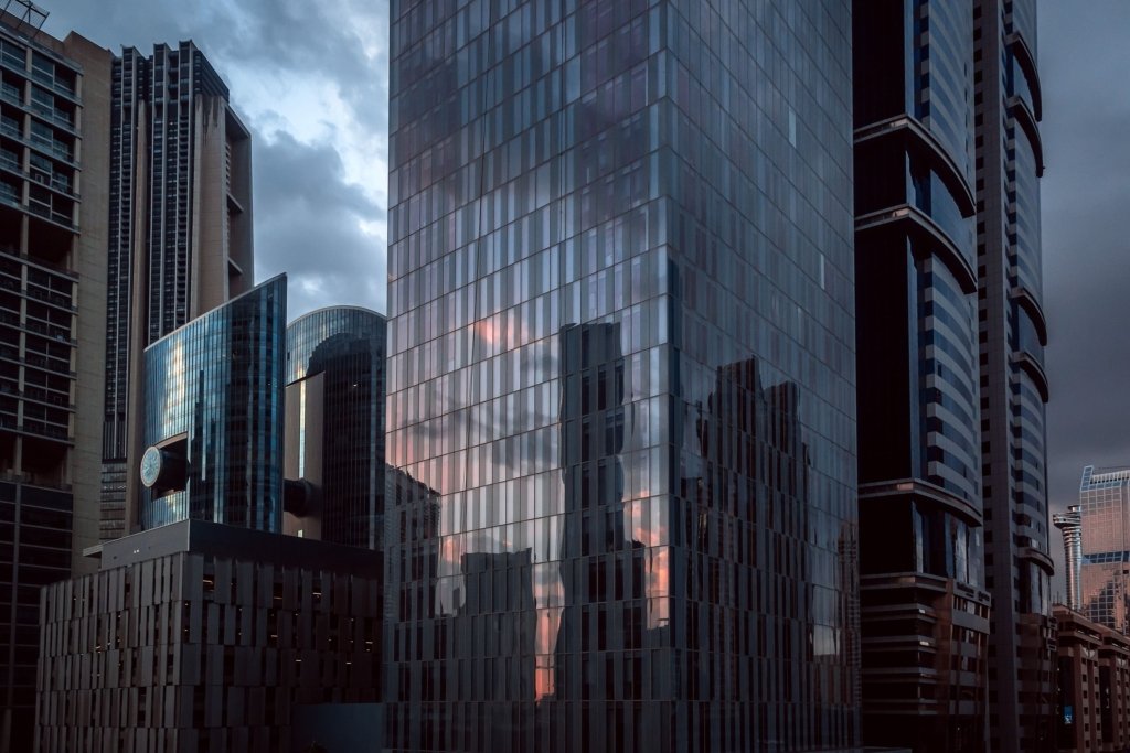 Modern glass office towers in a Dubai commercial business district at dusk
