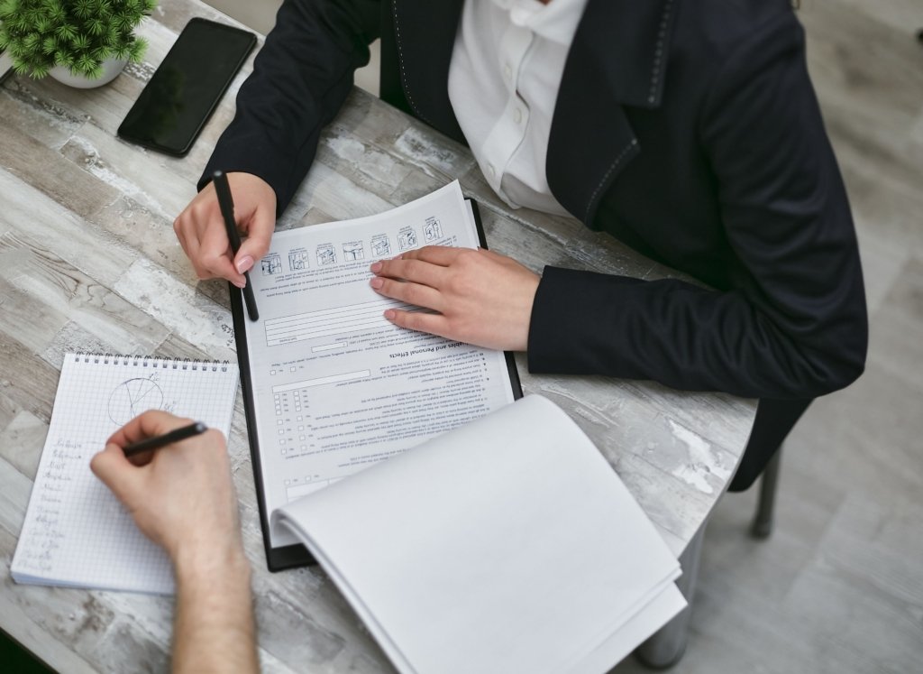 Buyer reviewing property purchase documents and checklist at a table