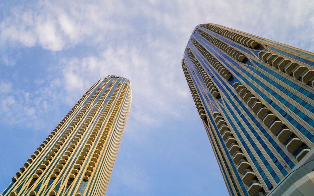 Dubai residential skyscrapers viewed from below against a blue sky, representing high rental yield investment areas