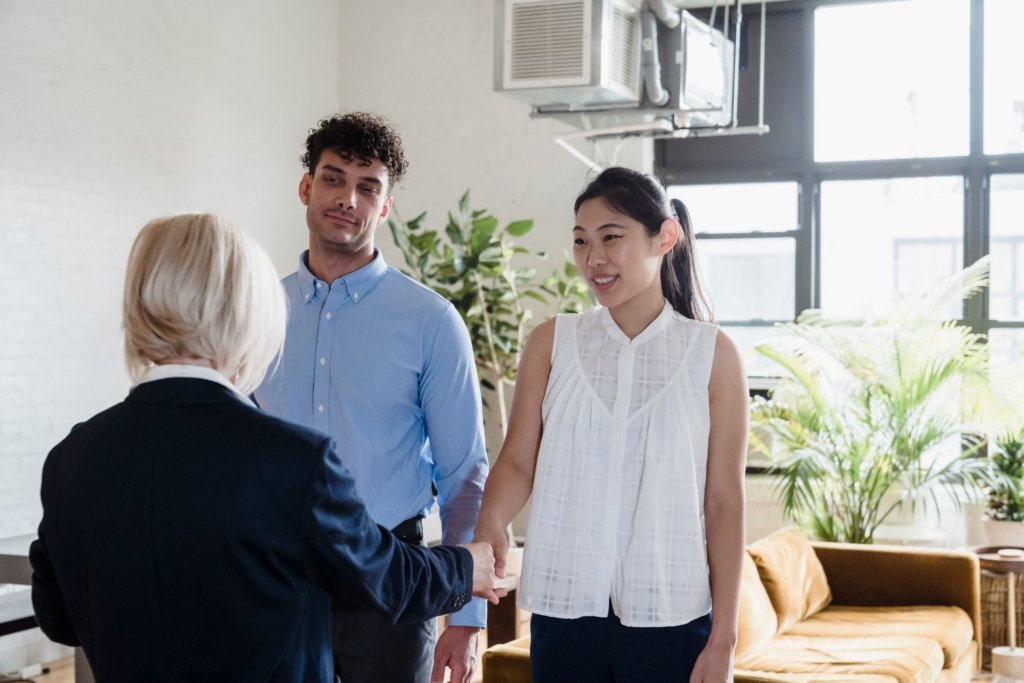Real estate agent shaking hands with a couple after discussing an off-plan property purchase in Dubai