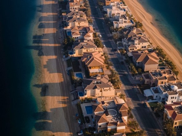 Aerial view of Palm Jumeirah frond villas with private pools along the beach