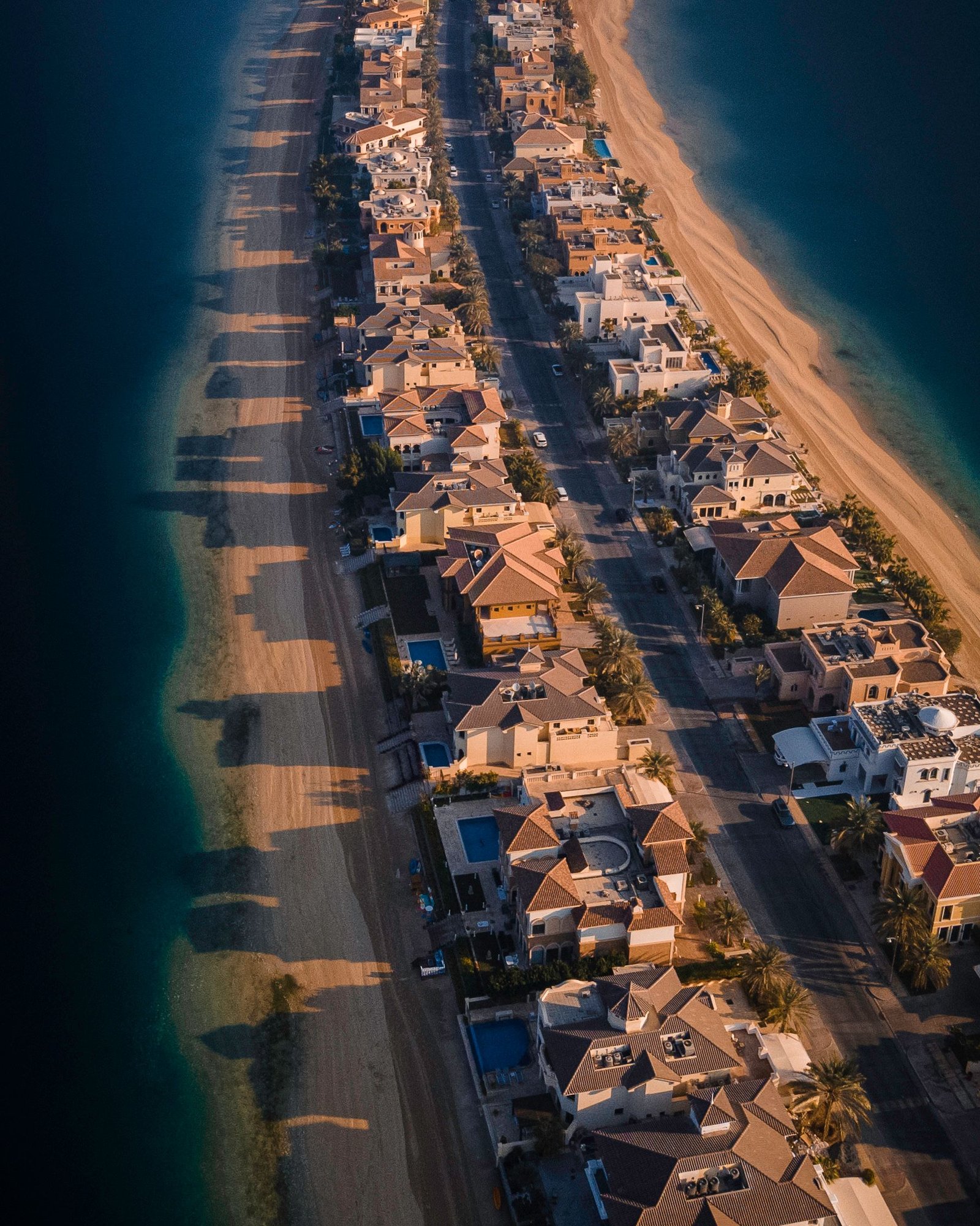 Aerial view of Palm Jumeirah frond villas with private pools along the beach