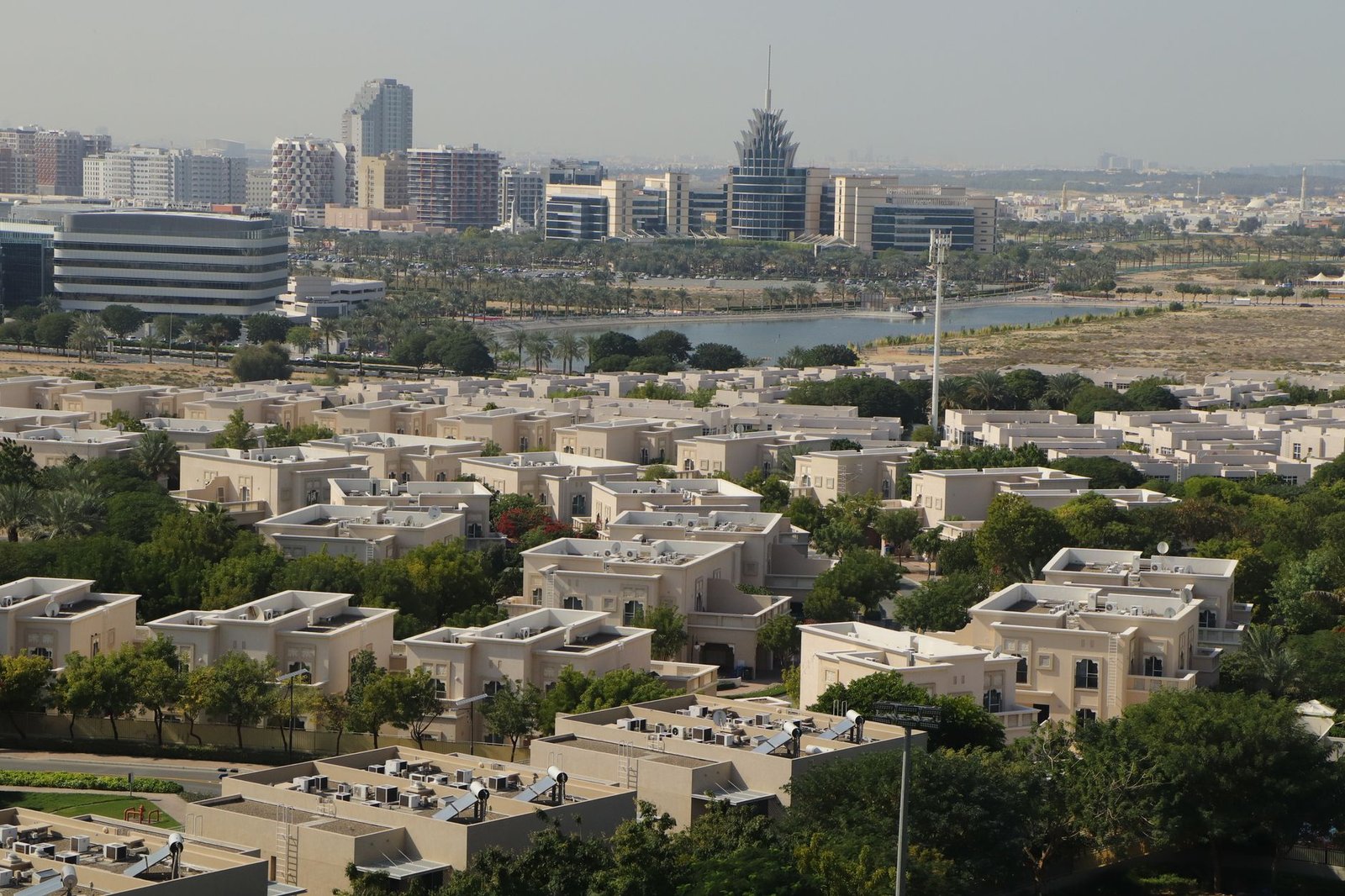 Aerial view of an established Dubai residential villa community with palm-lined streets, representing affordable freehold areas under AED 2 million
