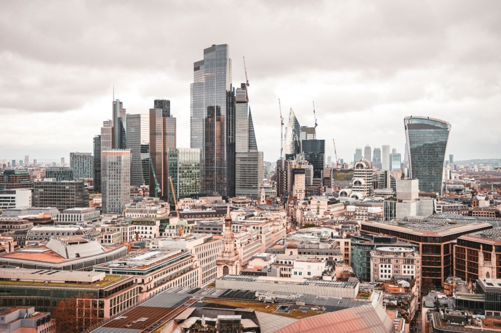 Aerial view of the City of London skyline with modern skyscrapers under overcast sky