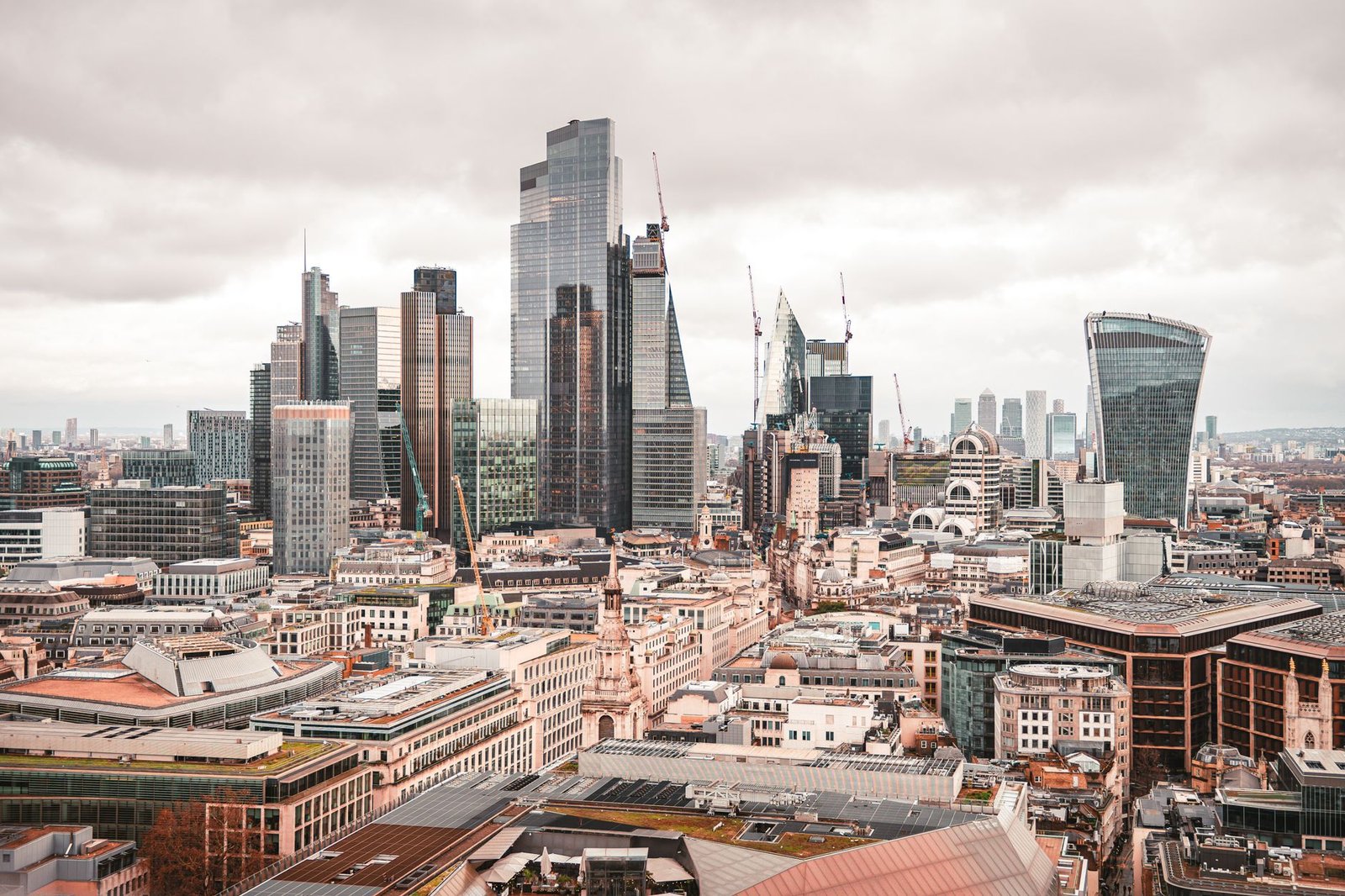 Aerial view of the City of London skyline with modern skyscrapers under overcast sky