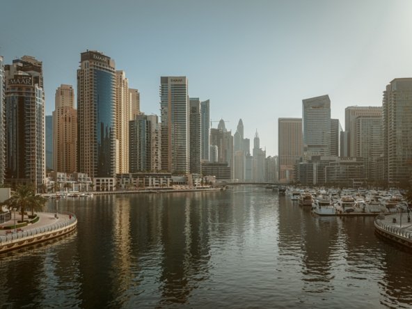 Dubai Marina waterfront skyline with high-rise towers, promenade and yachts moored along the marina