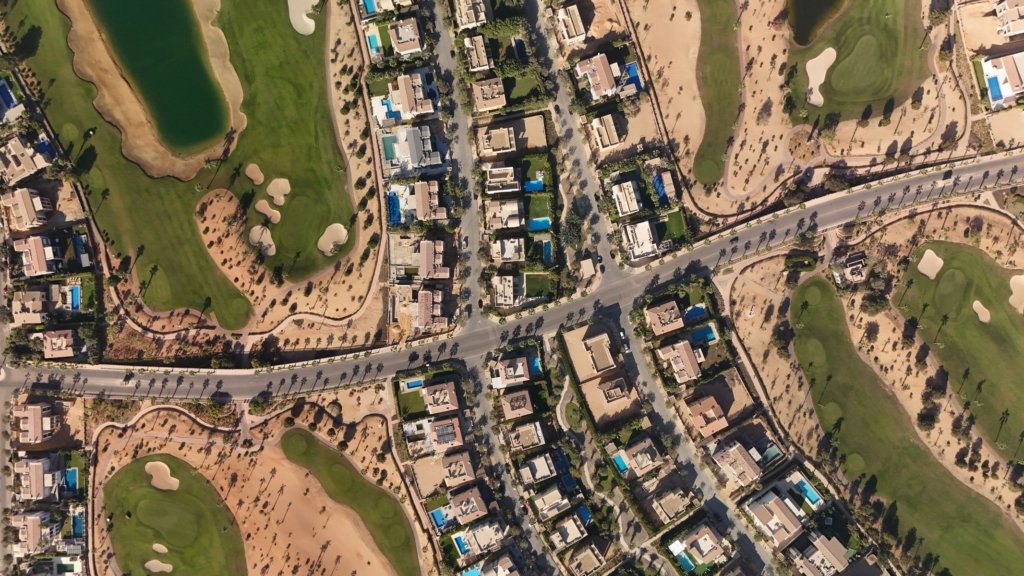 Aerial view of Dubai Hills Estate villa community with golf course fairways and lake
