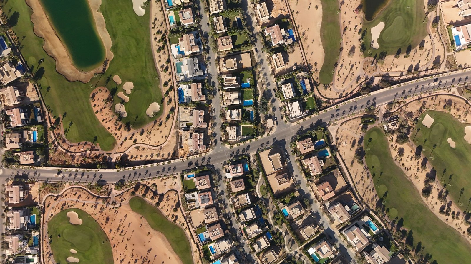 Aerial view of Dubai Hills Estate villa community with golf course fairways and lake