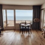 Beachfront holiday home living area with dining table and ocean view, representing a licensed Dubai short-term rental