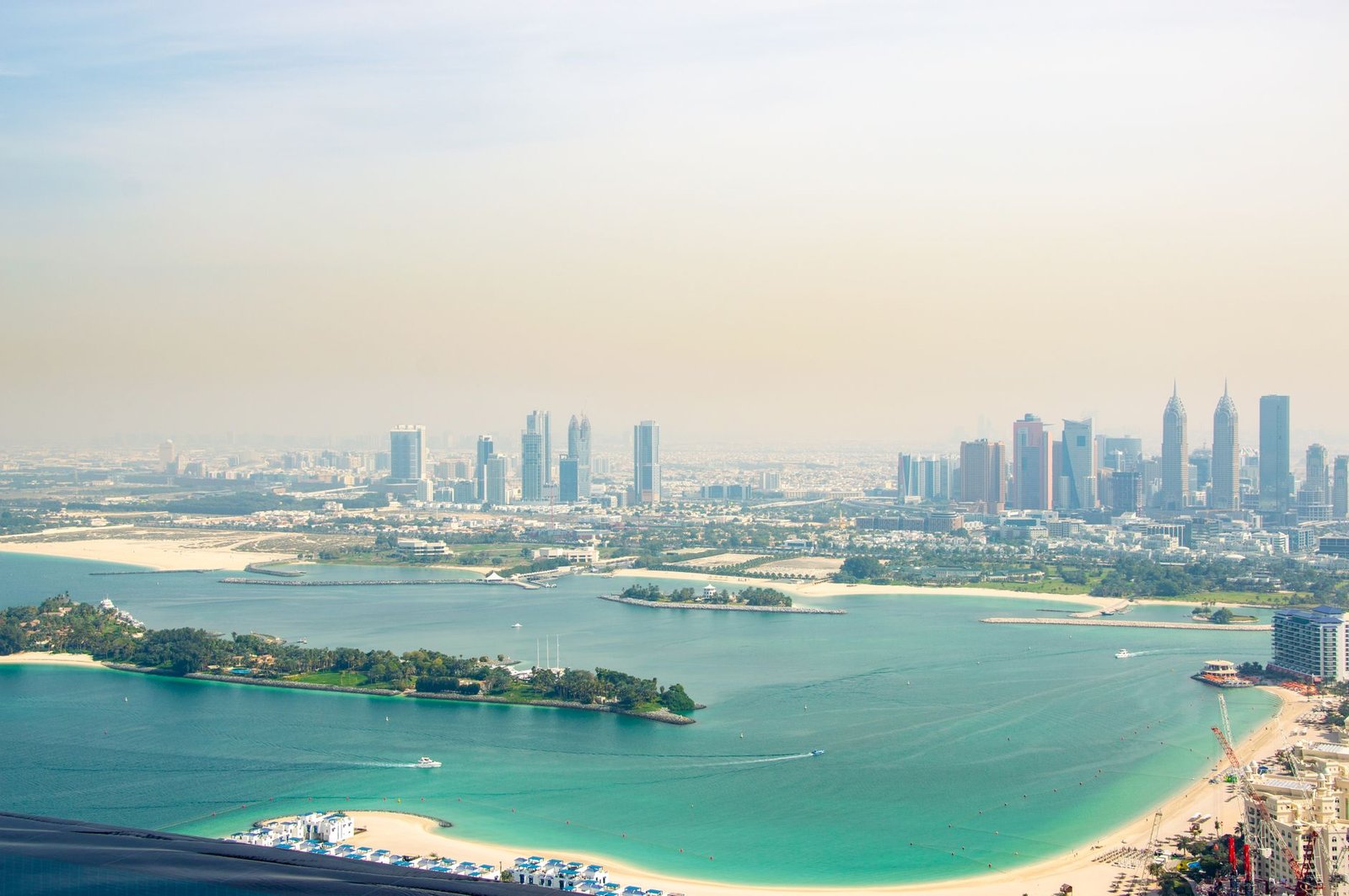 Aerial photograph of turquoise water, small islands and the Dubai skyline from above