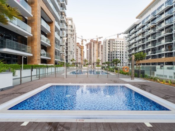 Apartment buildings around a tiled swimming pool in a Dubai residential community