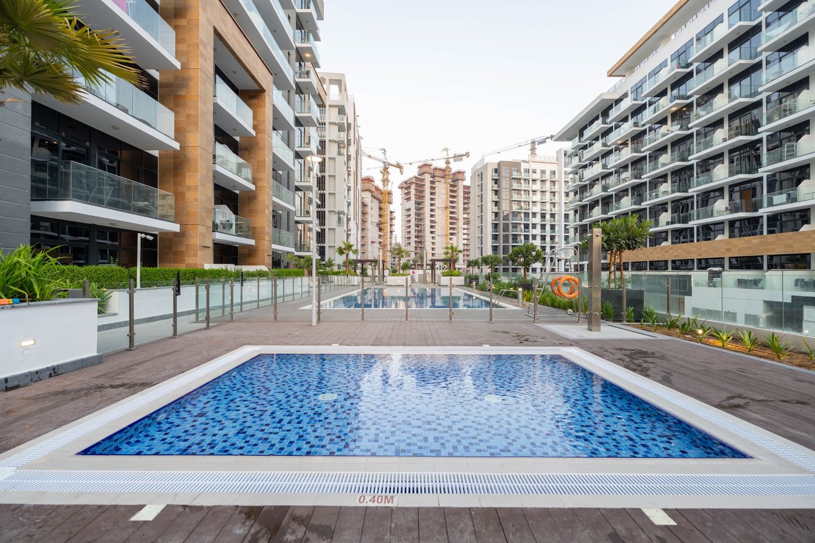 Apartment buildings around a tiled swimming pool in a Dubai residential community